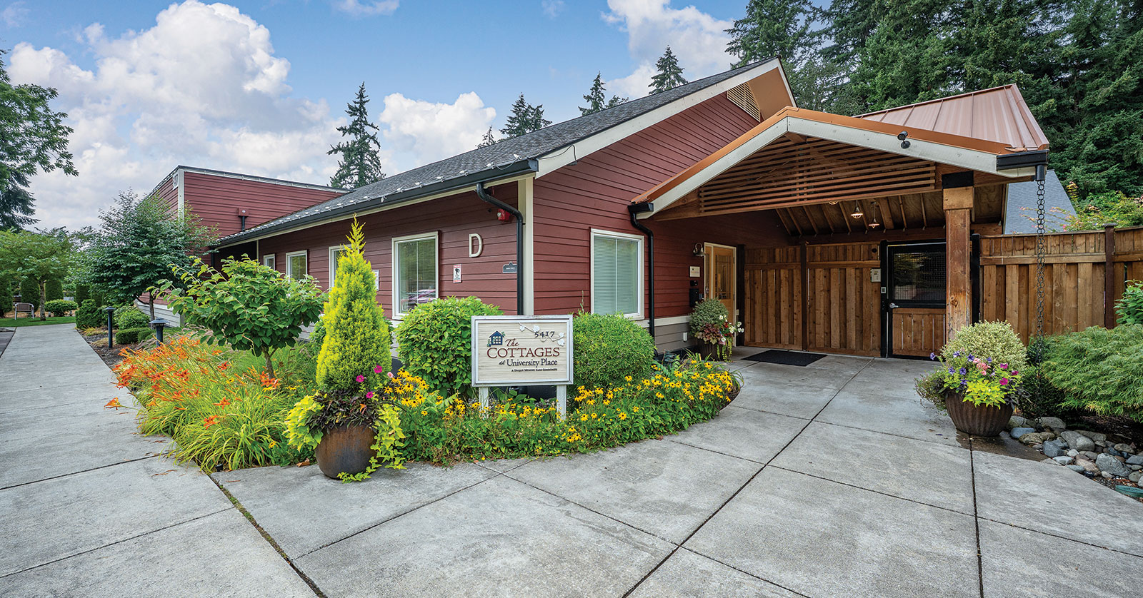 Charming cottage with flower gardens and welcoming entrance.