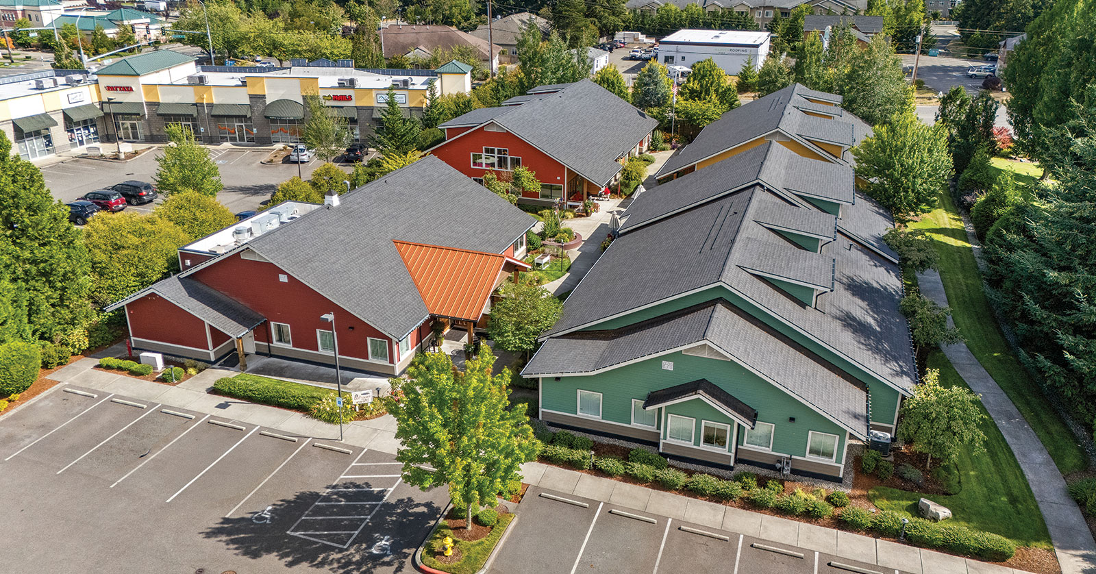 Colorful residential buildings with surrounding parking and greenery.