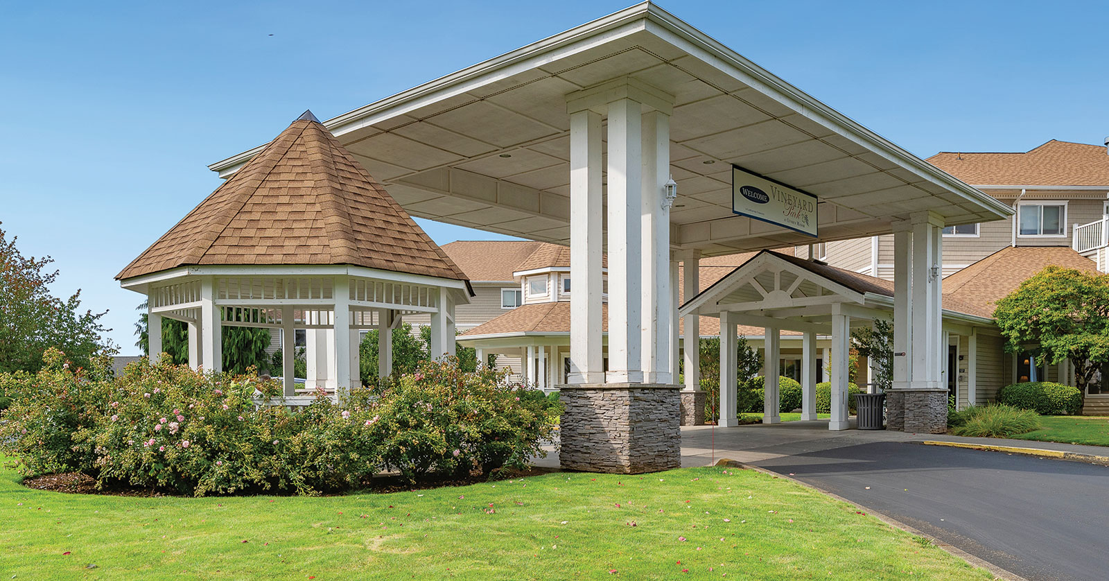 Quiet entrance with gazebo and landscaped greenery.