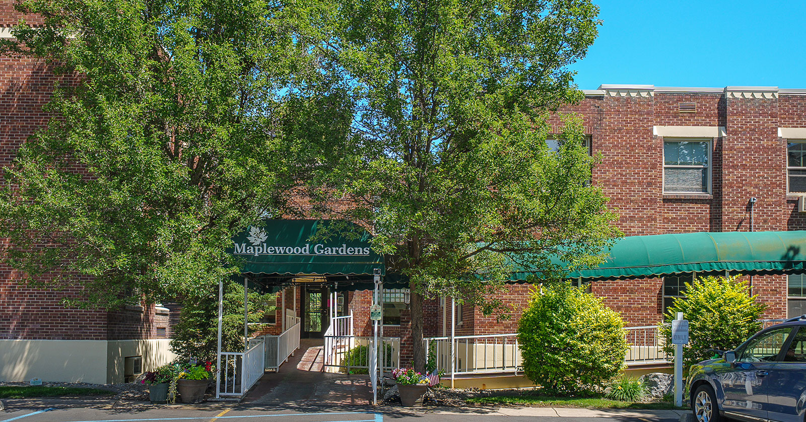 Brick building with greenery and entrance sign.