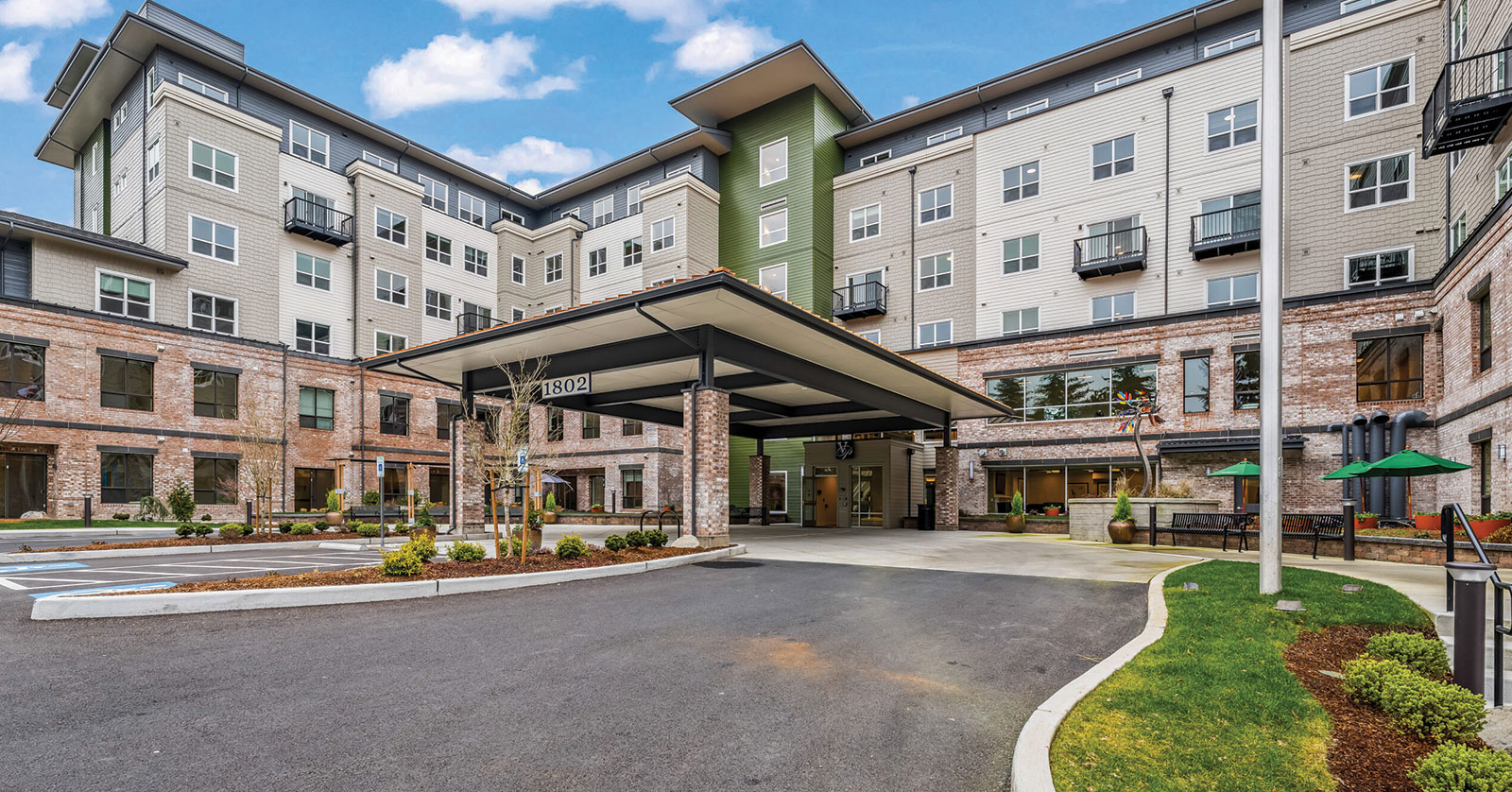 Modern apartment building with brick and green accents.