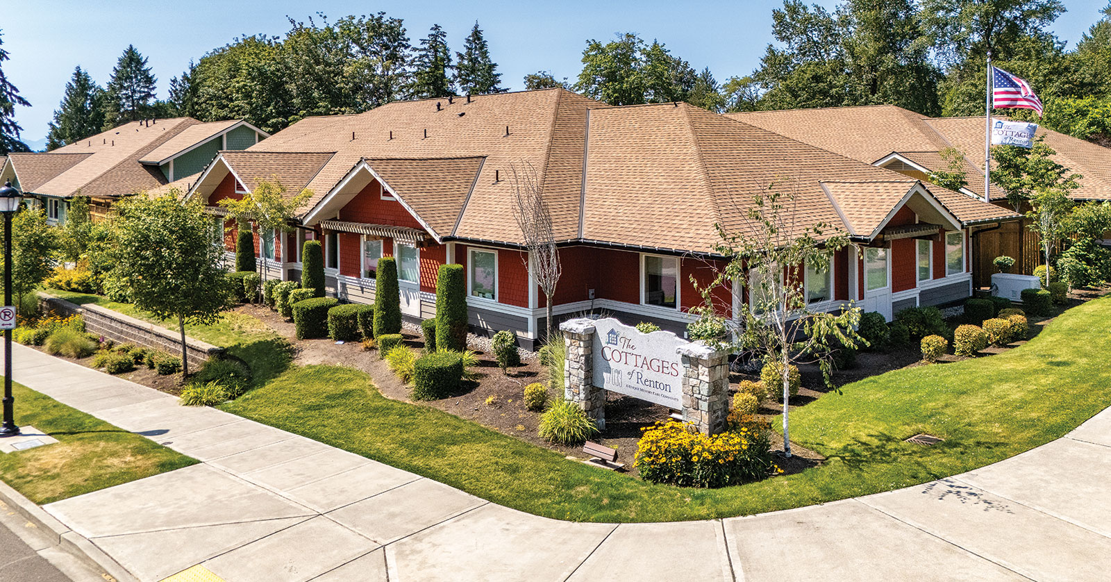 Residential cottages with landscaped gardens and American flag.